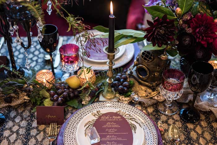 Haunting table design featuring dark and textural flowers, fruit, and oddities.