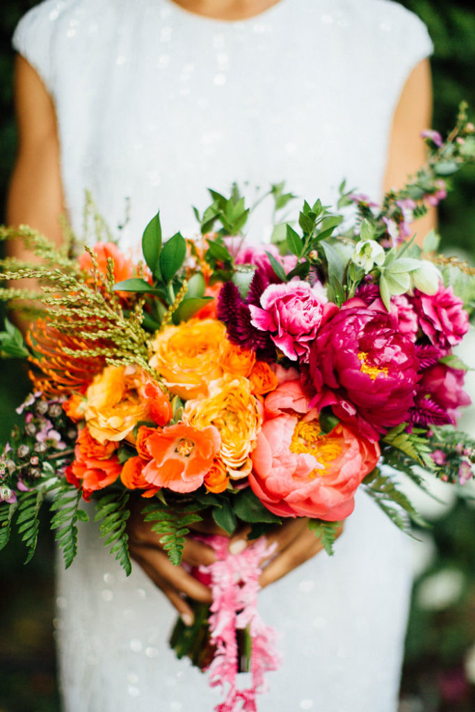 Brilliantly colorful bouquet featuring peonies, protea and ranunculus