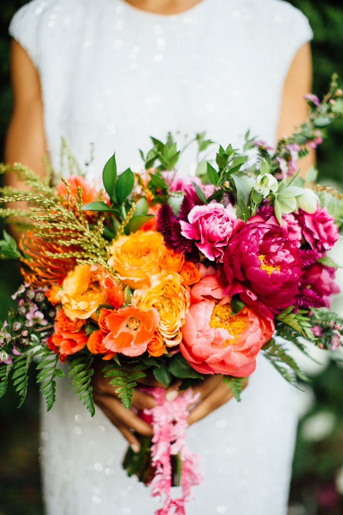 Brilliantly colorful bouquet featuring peonies, protea and ranunculus