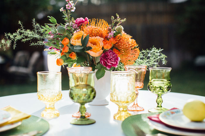 A colorful centerpiece and vintage glassware for a garden party