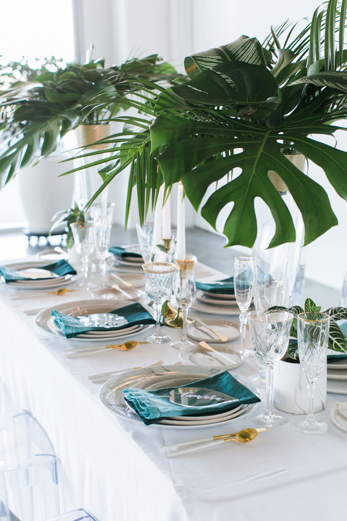 A modern tropical tablescape with tall centerpieces, and custom acrylic place cards.