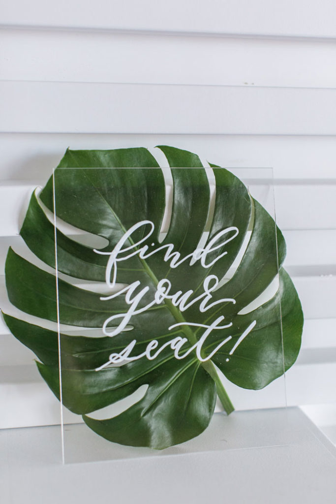 Acrylic "Find your Seat" Sign with Monstera Leaf.