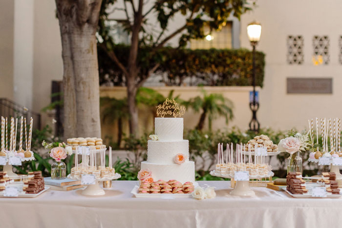 Beautiful desert table with cake, cake pops, and fresh flowers.