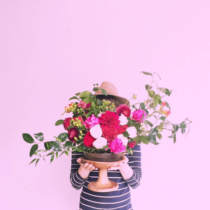 woman holding bright floral arrangement