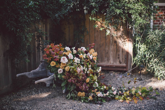 Installation in rustic wheel barrow with cascading fall flowers