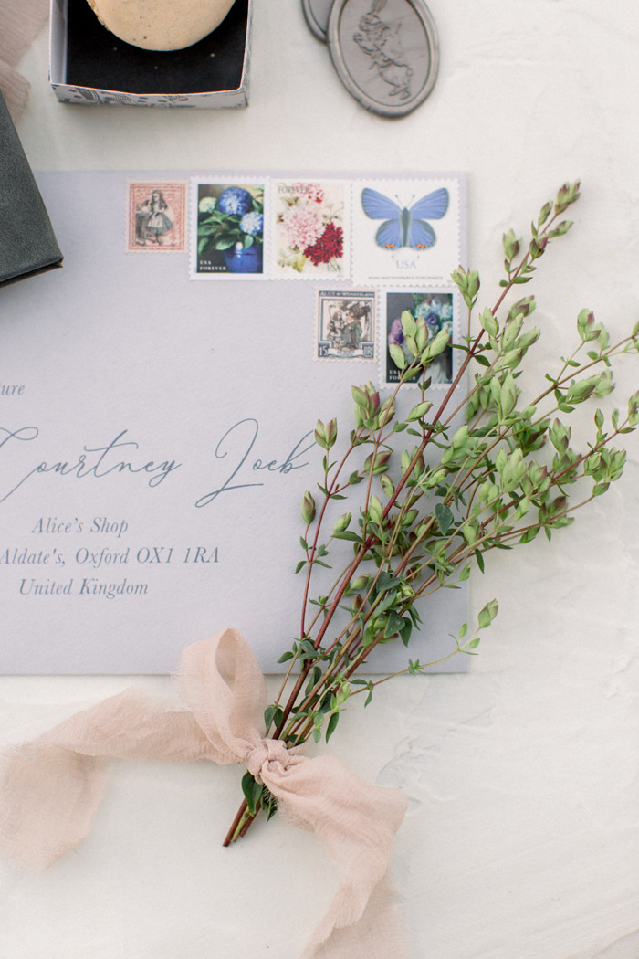 beautiful wedding envelope with calligraphy, vintage stamps, and fresh oregano