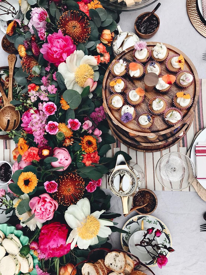 a birds-eye-view of a lush floral table garland and beautiful mini-cupcakes