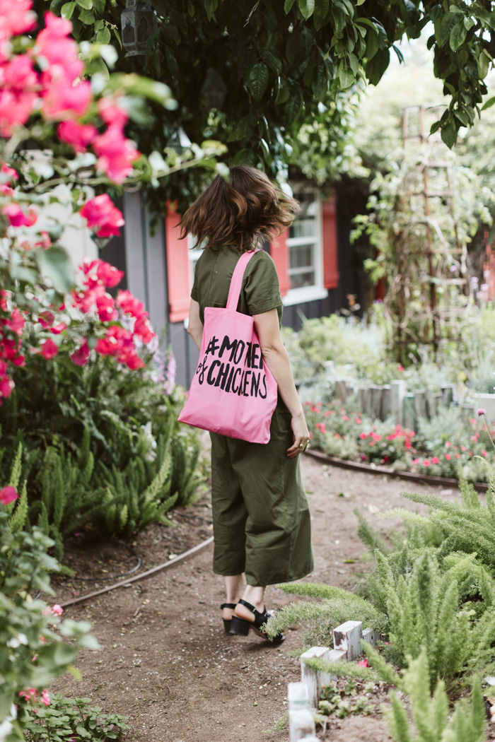 Winston & Main's Tabitha Abercrombie in the garden with her hand-painted "mother of chickens" tote