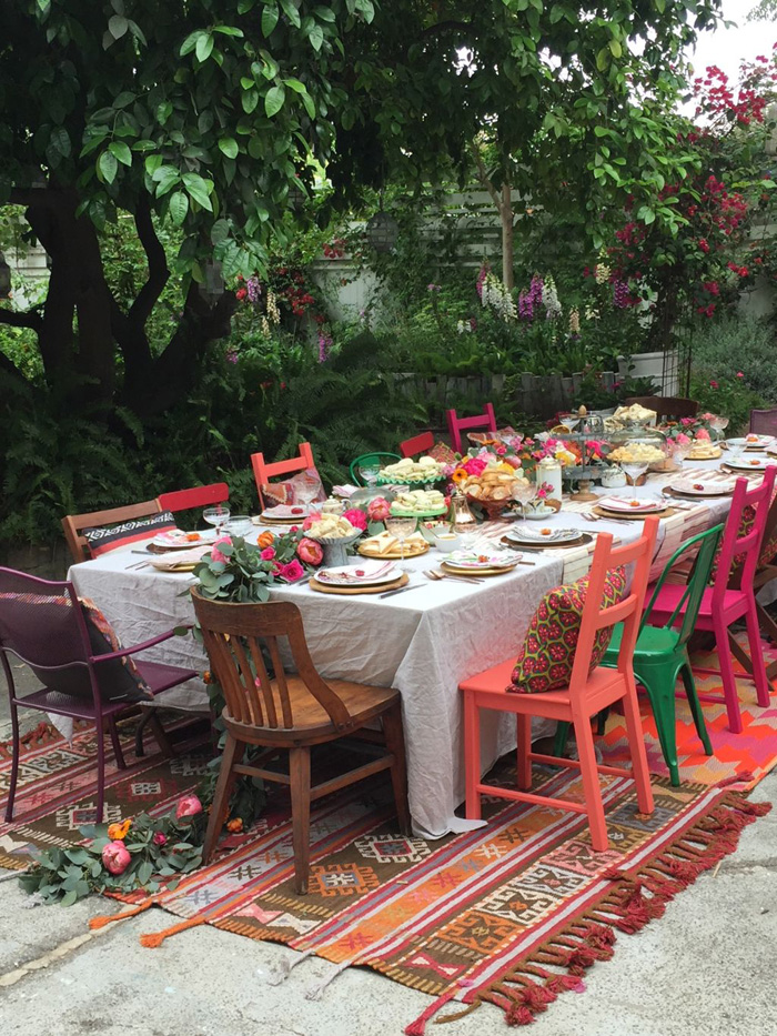tablescape with overflowing garland and colorful chairs for garden party
