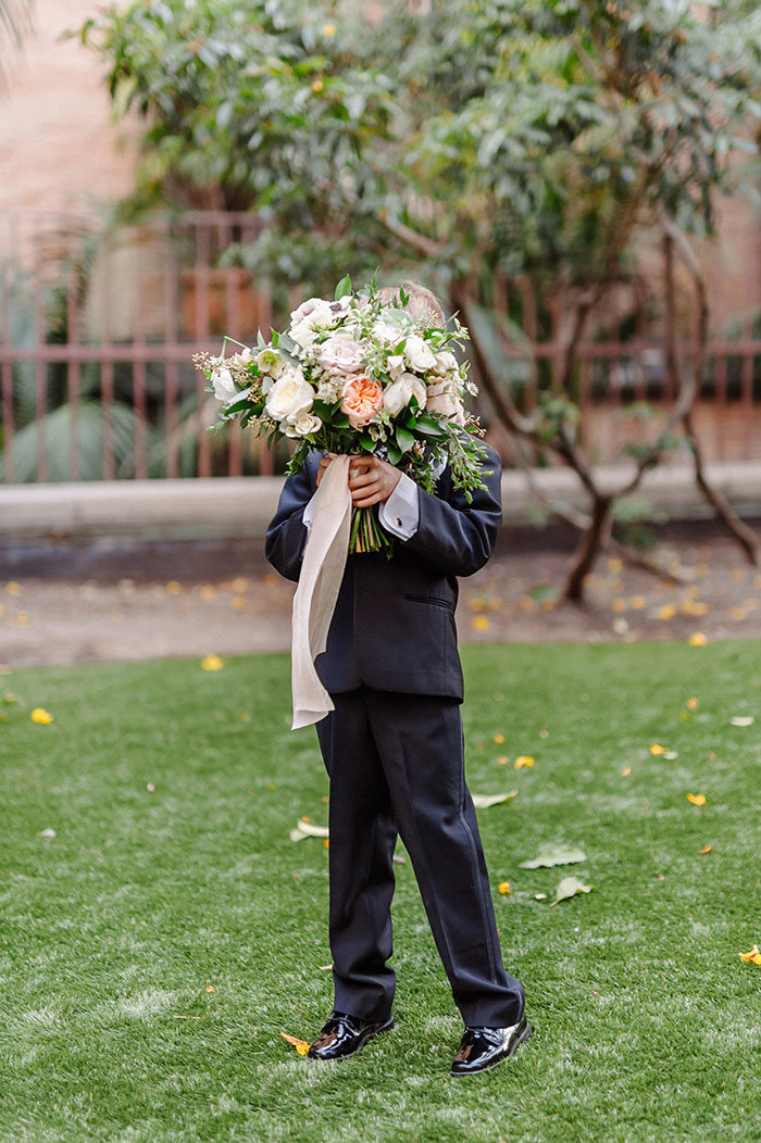 Cute ringbearer holding romantic bridal bouquet