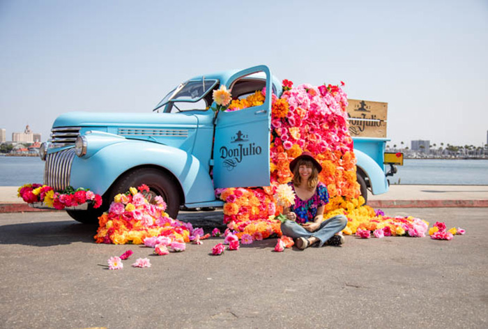 Tabitha Abercrombie of Winston & Main sits in front of her colorful floral installation for Don Julio Tequila.