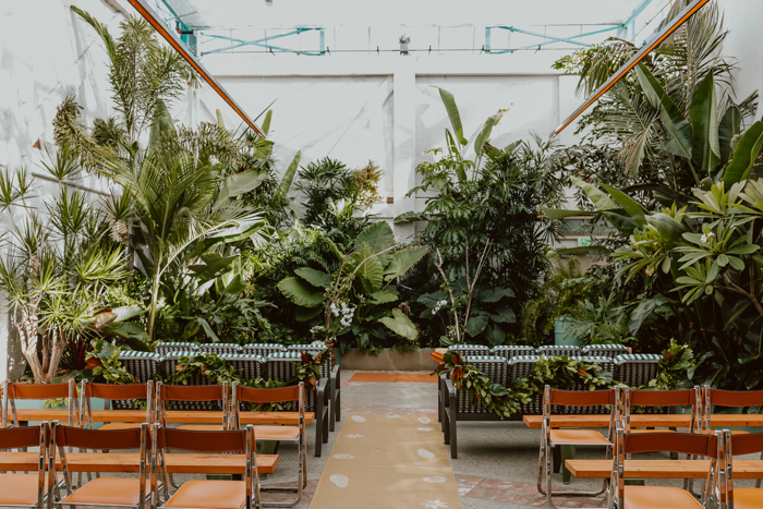 Magnolia ceremony garlands decorate the aisle at Valentine, the perfect sun lit greenhouse wedding venue, in Downtown Los Angeles.