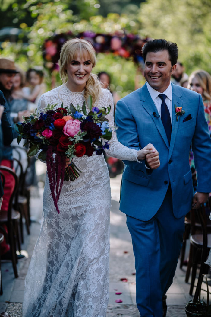 Our sweet newlywed couple walk down the aisle at their Houdini Estate wedding with jewel toned flowers designed by Winston and Main