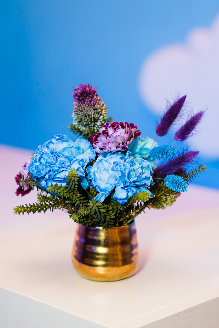 Blue and purple cocktail arrangement featuring carnations, allium, and bunny tail.