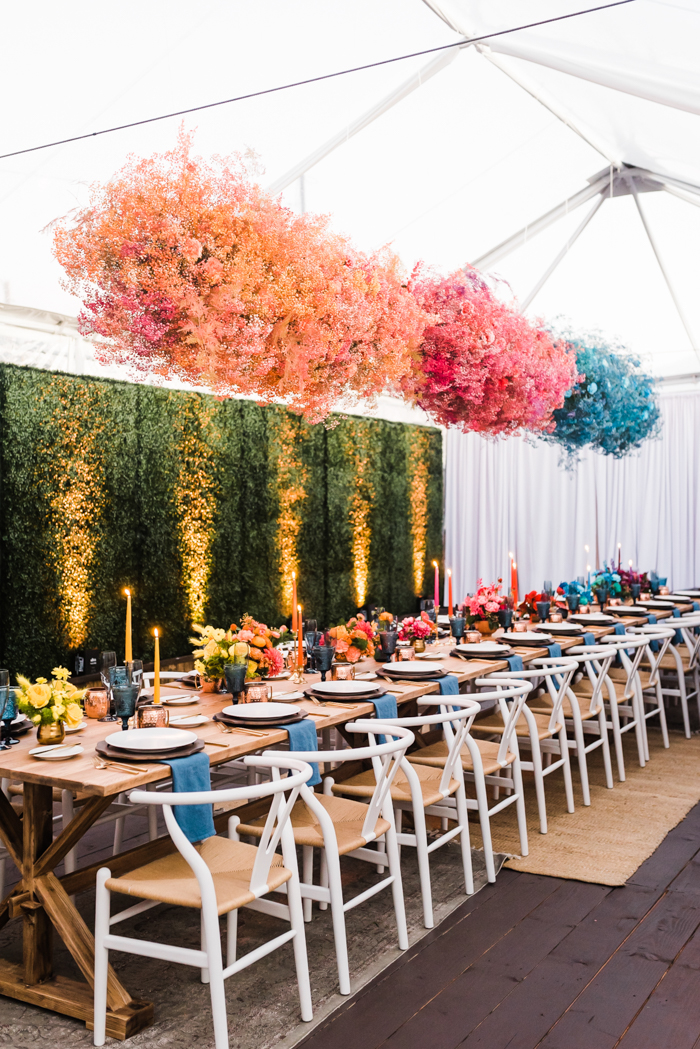 Bright and bold dyed babies breath clouds by Winston & Main hang over long table at colorful LA birthday celebration.