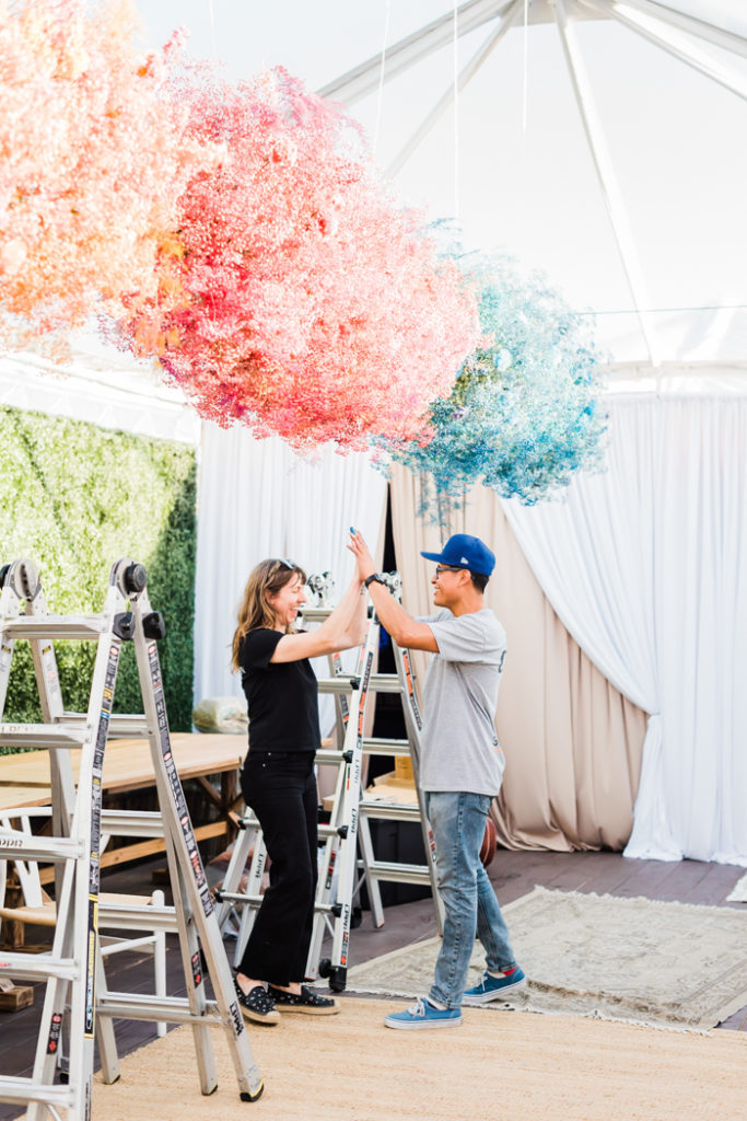 Hi-five under colorful floral clouds.