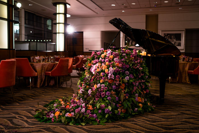 Piano with lush foam free floral installation spilling onto floor.