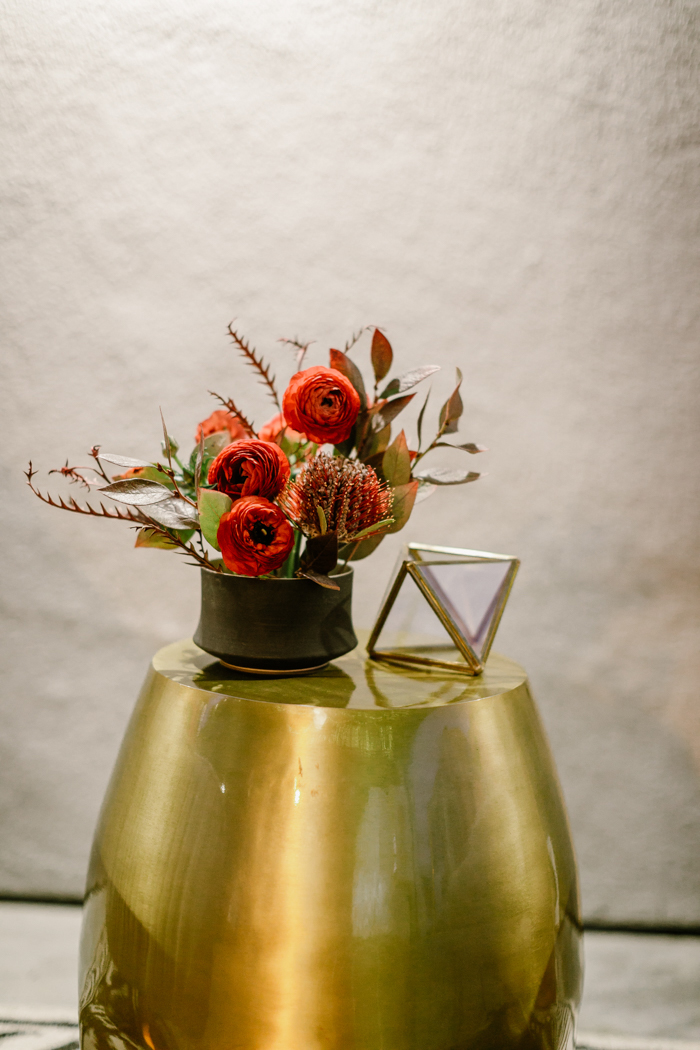 A bold & textural tomato red cocktail arrangement featuring ranunculus, and banksia.