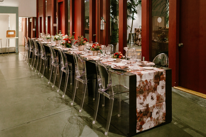 Long & dramatic tablescape featuring floral runner, and ombre red floral arrangements by Winston & Main.