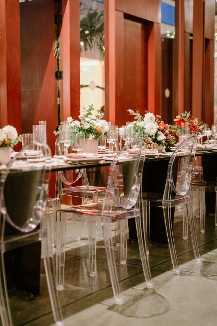 A floral table runner, ghost chairs, and ombre floral arrangements make for an interesting and textural tablescape.