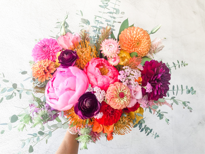 A bright & bold bouquet by Winston & Main featuring peony, dahlia, ranunculus, and zinnia for a 2020 elopement.