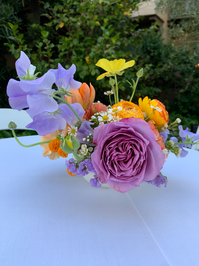 A colorful cocktail arrangement featuring local garden roses, peonies, california poppies and ranunculus by Winston & Main.