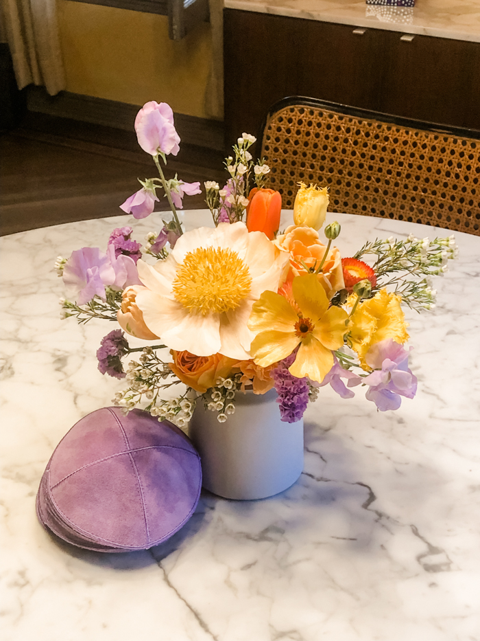 A beautiful cocktail arrangement by Winston and Main features a focal Claire de Lune peony and lavender sweet peas to coordinate with the wedding Kippahs.