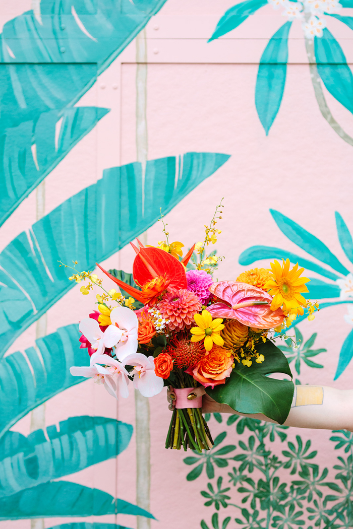 The bold & bright tropical bridal bouquet features phalaenopsis, anthurium, and sunny yellow rudbeckia.