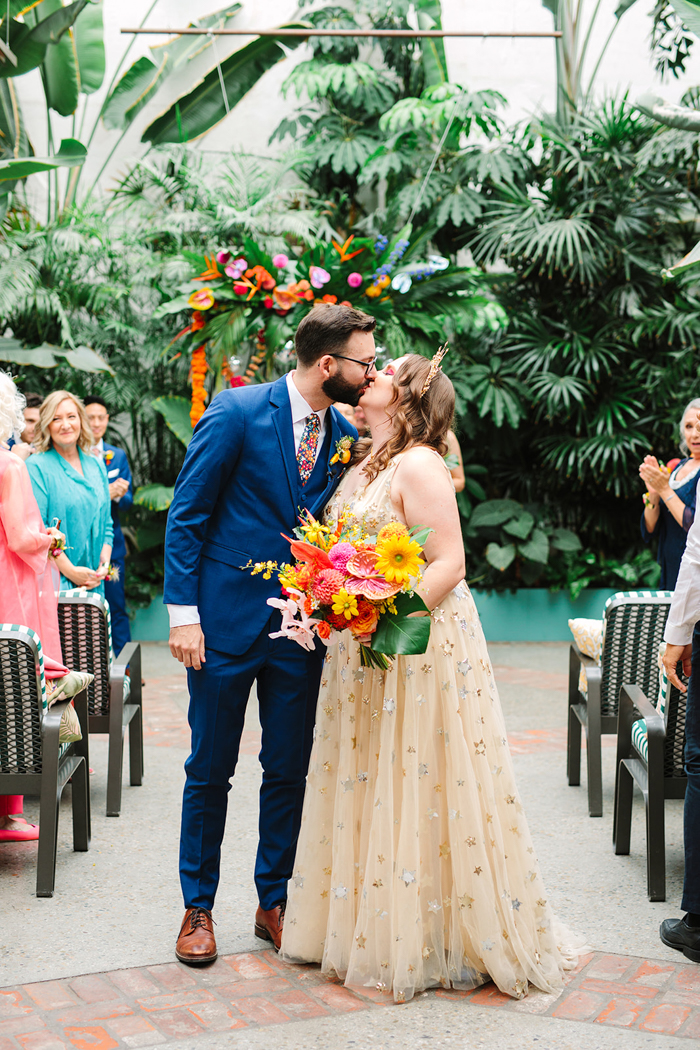 Just married! J&J share a quick kiss as they recess down the wedding aisle. 