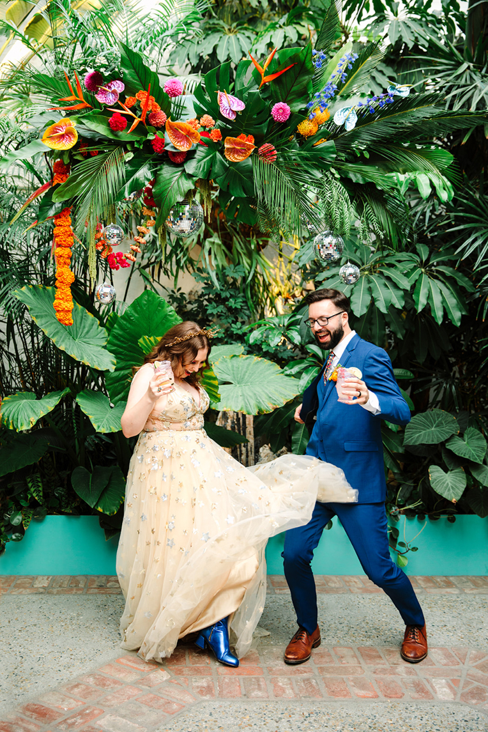 J&J dancing under their hanging tropical disco floral installation by Winston & Main.