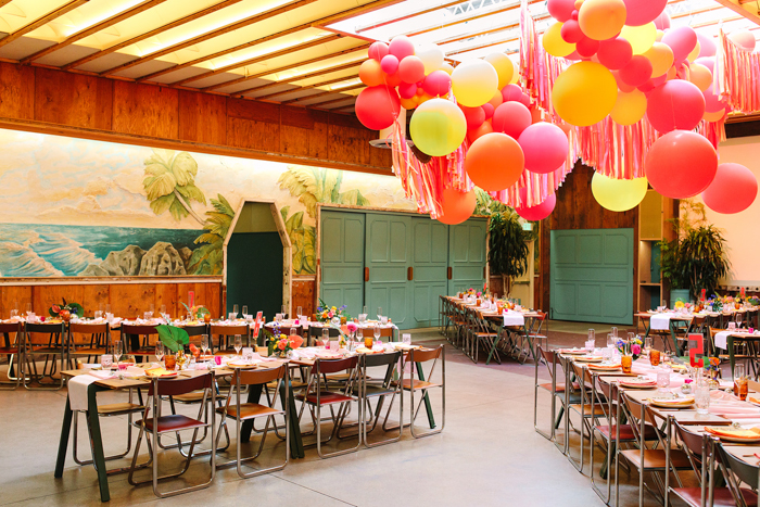 A bold and brilliant balloon installation by Balloonzilla is suspended over the colorful reception space.