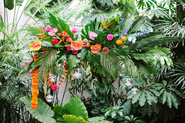 Tropical Greenery, Bold Blooms, & Disco Balls create this suspended wedding arch  at Valentine in DTLA.
