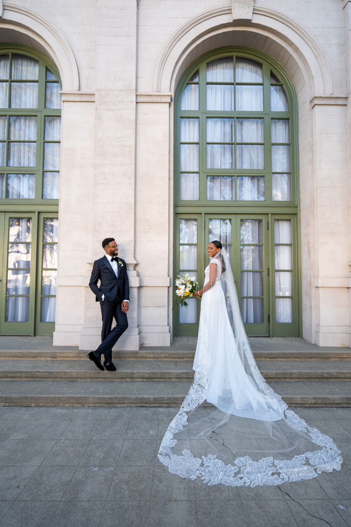 A wedding portrait on the staircase at The Ebell of Los Angeles, featuring a stunning veil by Julie Harris Designs. 