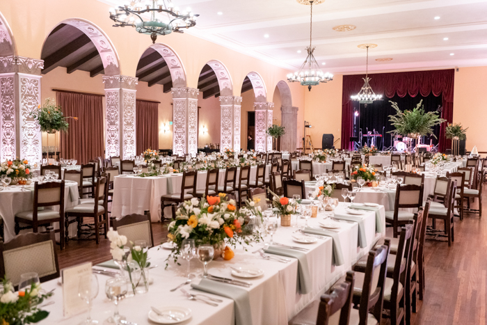 The reception featured a mix of long and round tables decorated with a variety of lush and textural centerpiece styles: high, low, large, and bud vases plus fresh citrus on the tables.