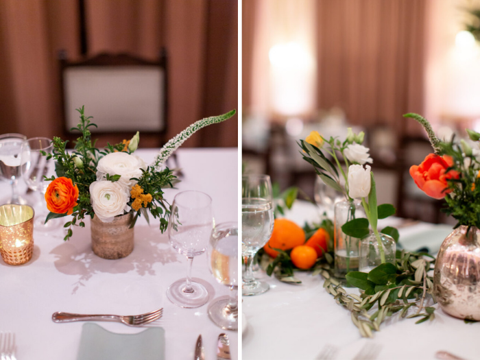 Details of reception guest tables with petite arrangements in gold vases, and glass bud vases with flowers in white and orange.