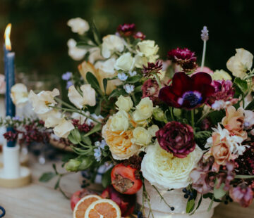 A lush and textural Spring centerpiece by Los Angeles Florist Winston & Main, created with sophisticated of yellow and moody burgundies.