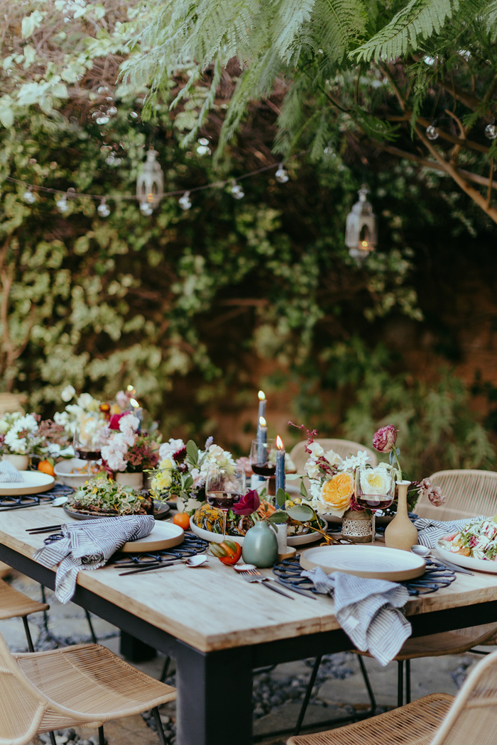 An outdoor tablescape overflowing with wild & whimsical floral centerpieces.