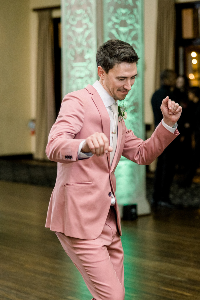 Our groom dances the night away wearing a colorful, custom pink wedding suit and signature Winston & Main air plant boutonniere at The Ebell of Los Angeles. 